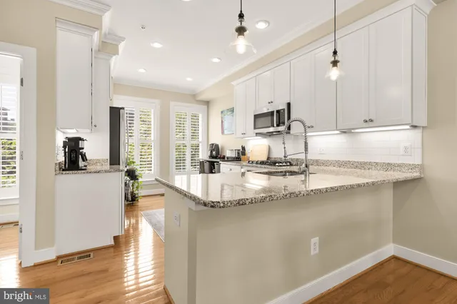 a kitchen with kitchen island granite countertop a sink window and cabinets
