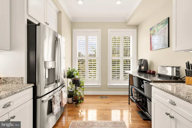 a kitchen with granite countertop a refrigerator and a stove top oven