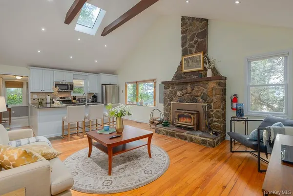 a living room with furniture a fireplace and a dining table with wooden floor