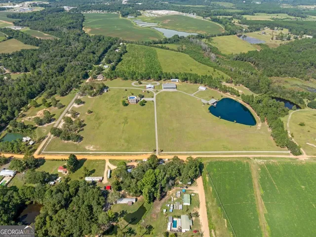 a front view of a house with a garden and lake view