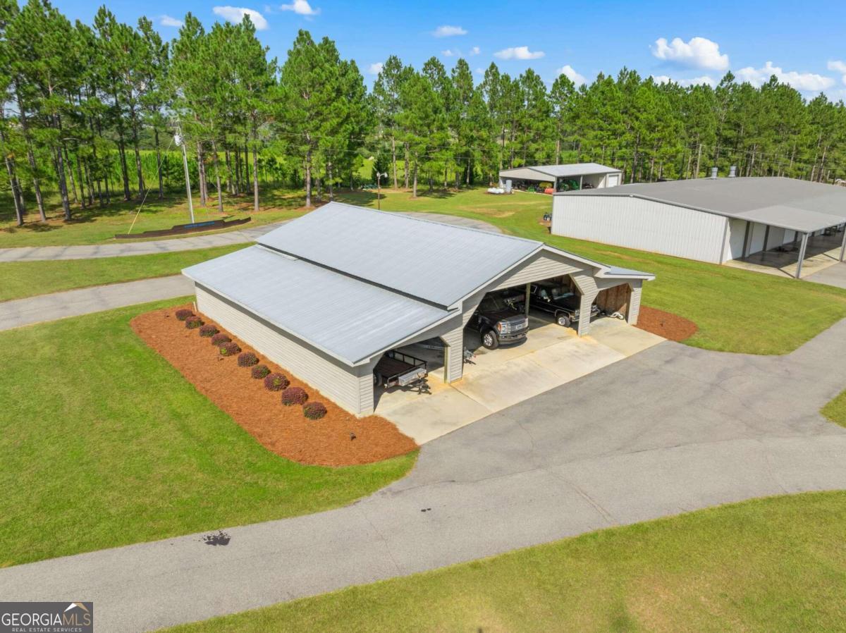 375 Dasher Street Lyons, GA 30436 - Photo 92 of 100 a view of a swimming pool with a yard and trees in the background