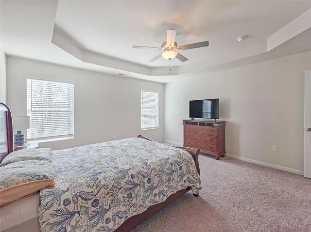 a spacious bedroom with a bed and a flat screen tv