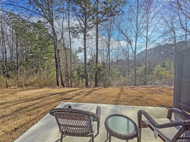 a view of a backyard with table and chairs and wooden fence