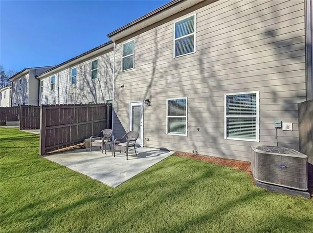 a view of house with backyard and sitting area