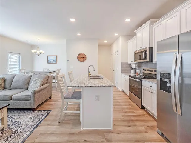 a large kitchen with stainless steel appliances kitchen island granite countertop a refrigerator and a stove top oven