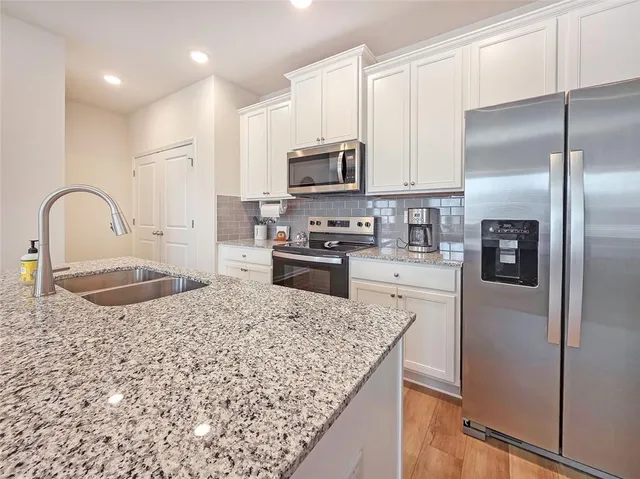 a kitchen with kitchen island granite countertop a stove a sink and a refrigerator