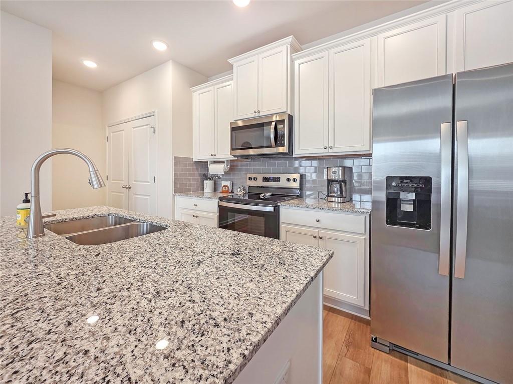 1120 Edinberg Drive Villa Rica, GA 30180 - Photo 8 of 35 a kitchen with kitchen island granite countertop a stove a sink and a refrigerator