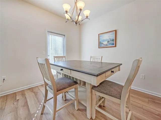 a view of a dining room with furniture and a chandelier
