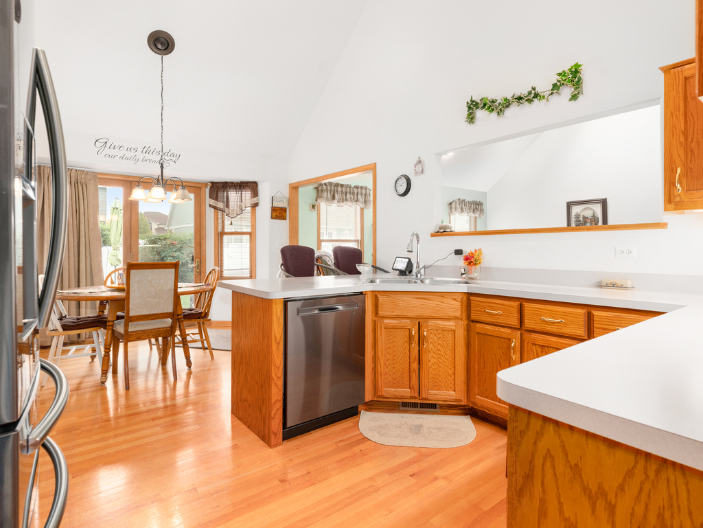 704 Clifford Drive Minooka, IL 60447 - Photo 3 of 25 a kitchen with stainless steel appliances granite countertop a sink a stove and a refrigerator