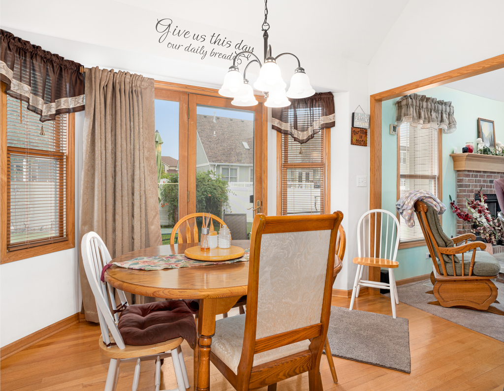 704 Clifford Drive Minooka, IL 60447 - Photo 7 of 25 a dining room with furniture a chandelier and wooden floor