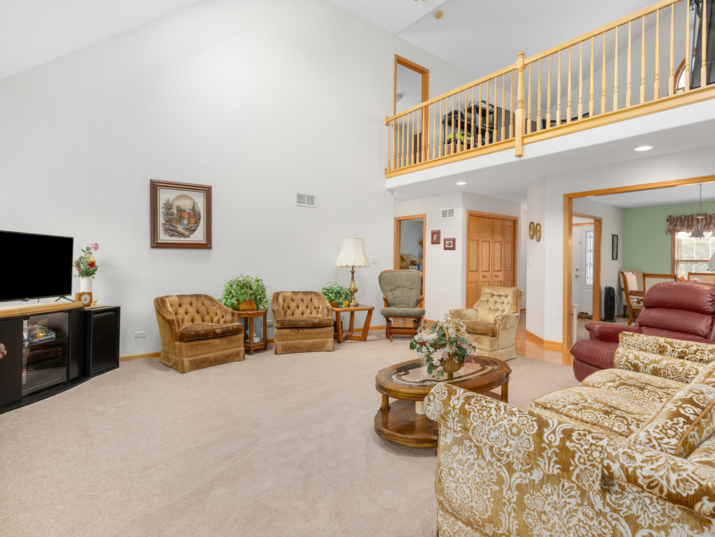704 Clifford Drive Minooka, IL 60447 - Photo 8 of 25 a living room with furniture and a flat screen tv