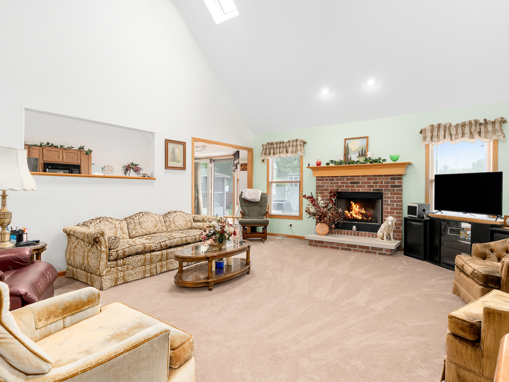 704 Clifford Drive Minooka, IL 60447 - Photo 9 of 25 a living room with furniture a flat screen tv and a fireplace