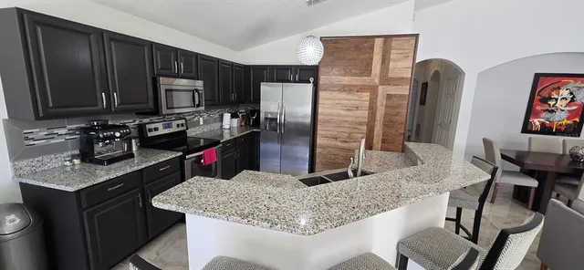 a kitchen with stainless steel appliances granite countertop a sink stove and refrigerator