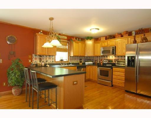 Kitchen. Stainless appliances, ceramic backsplash and natural oak cabinets accentuate the well equipped kitchen