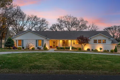 a front view of house with yard and green space