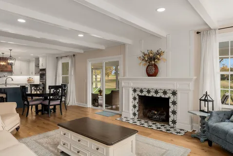 a living room with furniture large window and fireplace