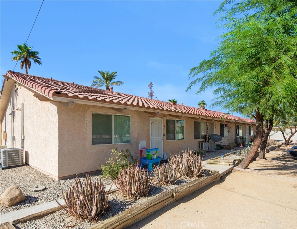 27700 Avenida Terrazo Cathedral City, CA 92234 - Photo 2 of 25 a view of a house with large windows and potted plants