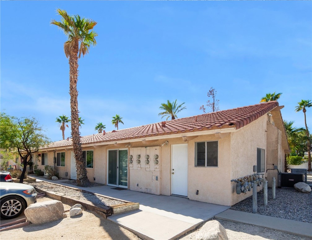 27700 Avenida Terrazo Cathedral City, CA 92234 - Photo 9 of 25 a view of a white house with large windows and a table