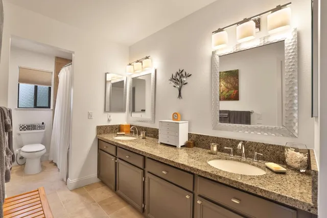 a bathroom with a granite countertop sink and a mirror
