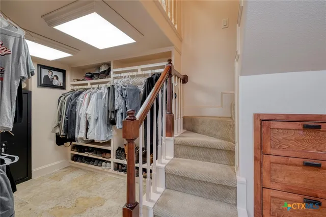 a view of walk in closet with clothes and shoes
