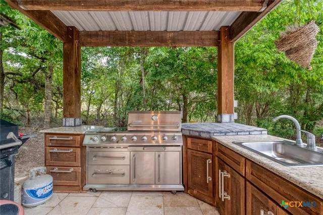 a backyard of a house with fountain table and chairs