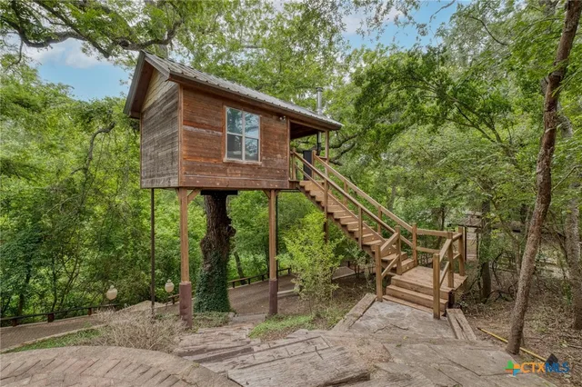 a backyard of a house with lots of green space and a fountain