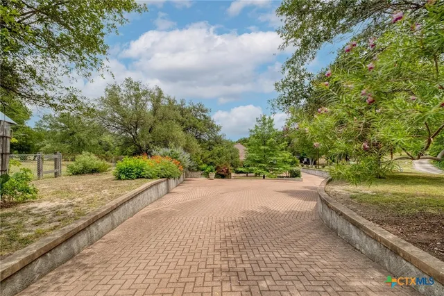 a view of a street with a yard and a wooden fence
