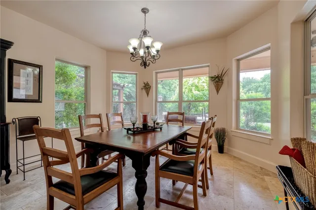 a view of a dining room with furniture a livingroom and chandelier