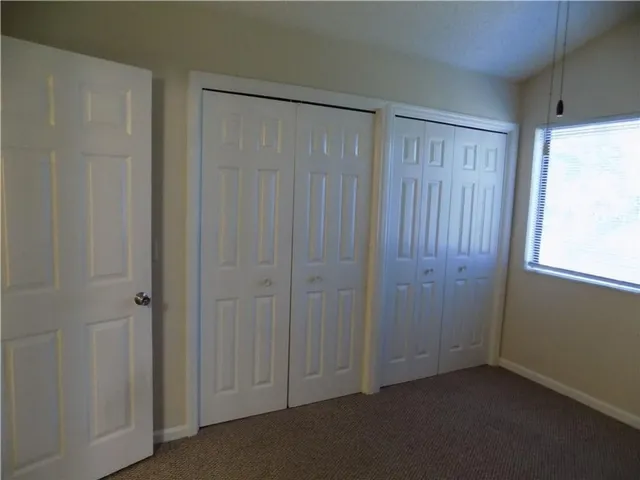 a view of an empty room with closet area
