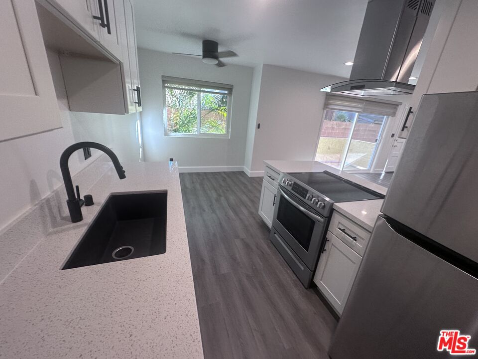 2228 20th Street, Unit 2 Santa Monica, CA 90405 - Photo 10 of 43 a kitchen with a stove a faucet and a window