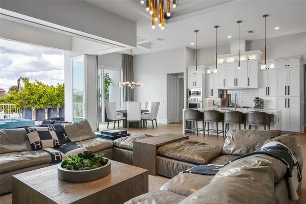 a kitchen with stainless steel appliances granite countertop a table chairs and a refrigerator