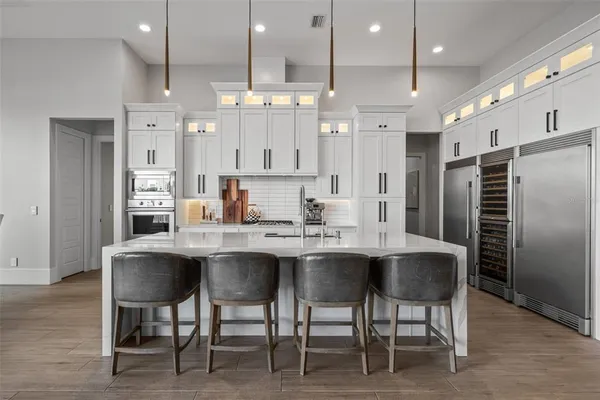 a kitchen with stainless steel appliances a sink a counter top space and living room view