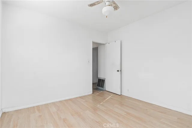 an empty room with a ceiling fan and carpet