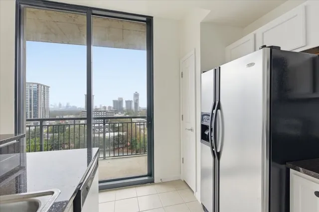 a view of a refrigerator in kitchen and a window