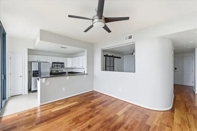 a view of a kitchen with wooden floor and a ceiling fan