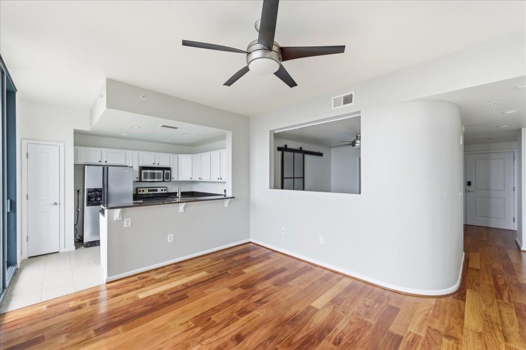 3040 Peachtree Road Northwest, Unit 805 Atlanta, GA 30305 - Photo 9 of 36 a view of a kitchen with wooden floor and a ceiling fan