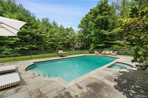 a view of a swimming pool with a yard and sitting area