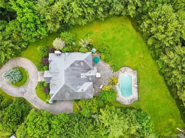 an aerial view of a house with a swimming pool a yard and a fountain