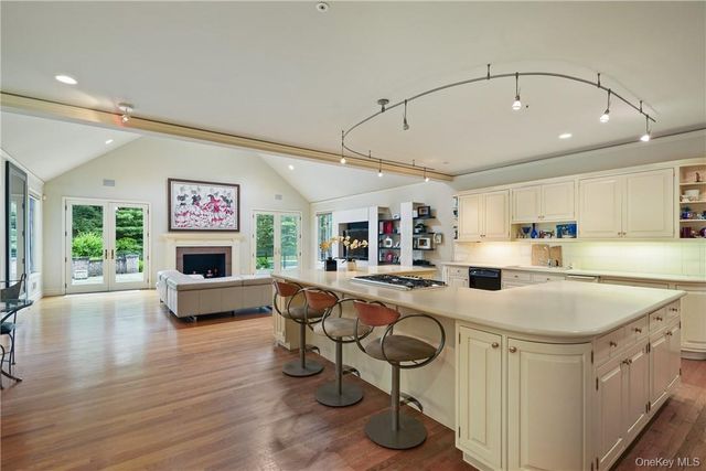 a kitchen with stainless steel appliances granite countertop a sink dishwasher and a stove with wooden floor