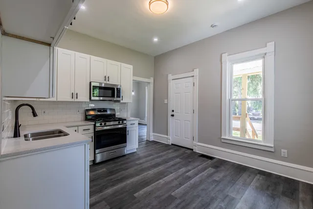 a kitchen with sink a microwave and cabinets