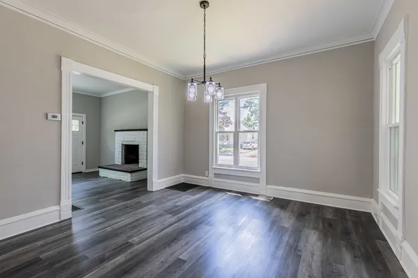 a view of a room with wooden floor fireplace and windows