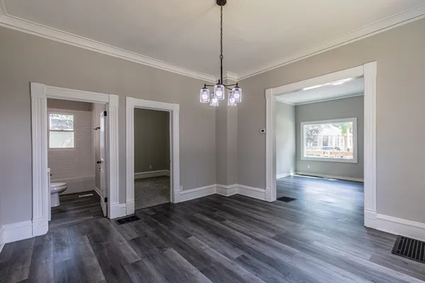 a view of a hallway with wooden floor and a living room