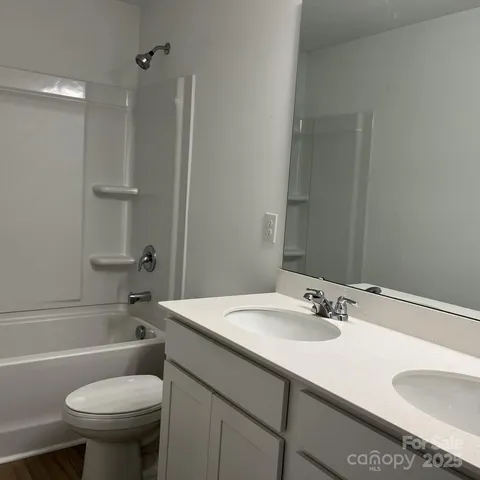 a bathroom with a sink toilet vanity and shower