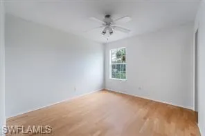 an empty room with a window and a ceiling fan