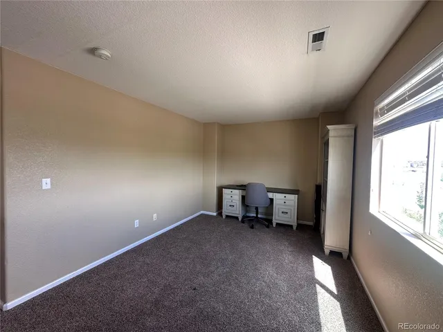 an empty room with windows and furniture