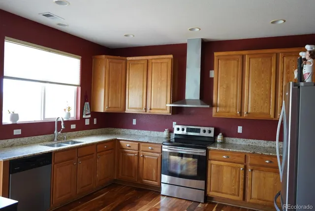 a kitchen with stainless steel appliances granite countertop sink stove and cabinets