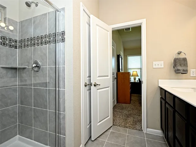 a bathroom with a sink mirror and shower