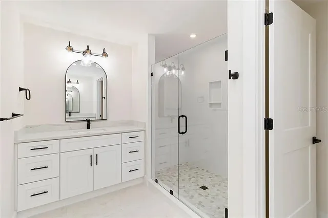 a bathroom with a double vanity sink mirror and shower