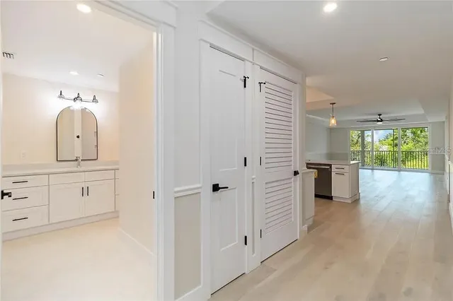 a kitchen with white cabinets and wooden floors