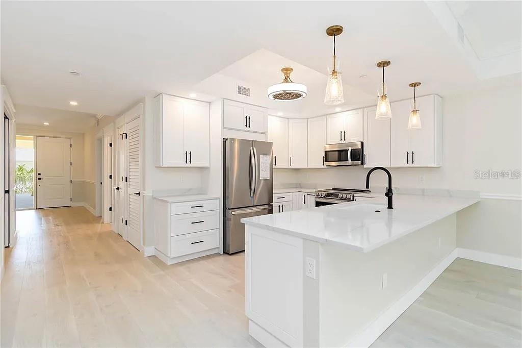 Undisclosed Address Osprey, FL 34229 - Photo 8 of 39 a kitchen with stainless steel appliances a refrigerator sink and white cabinets